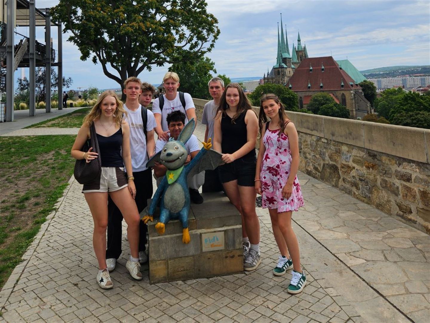 Elevar står rundt ein statue av ein teikneserieaktiv flaggermus.