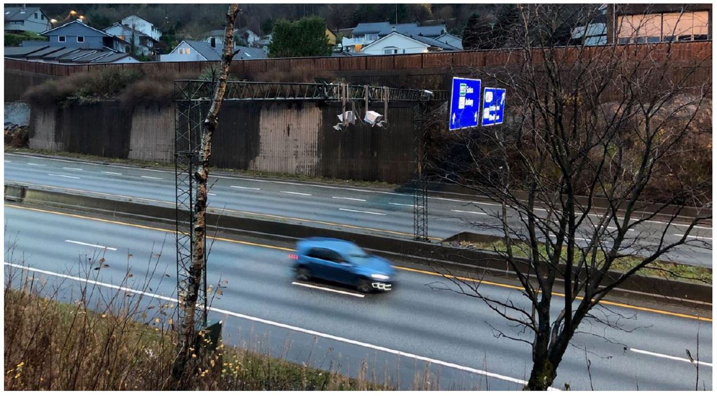 blå bil køyrar forbi bompengekamera