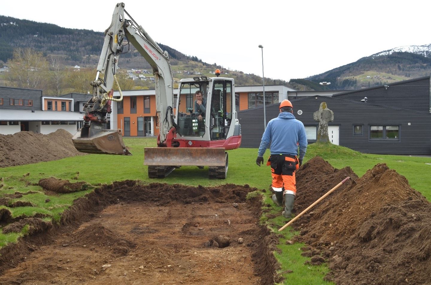 foto av arkeolog og gravemaskinførar i arbeid på Voss