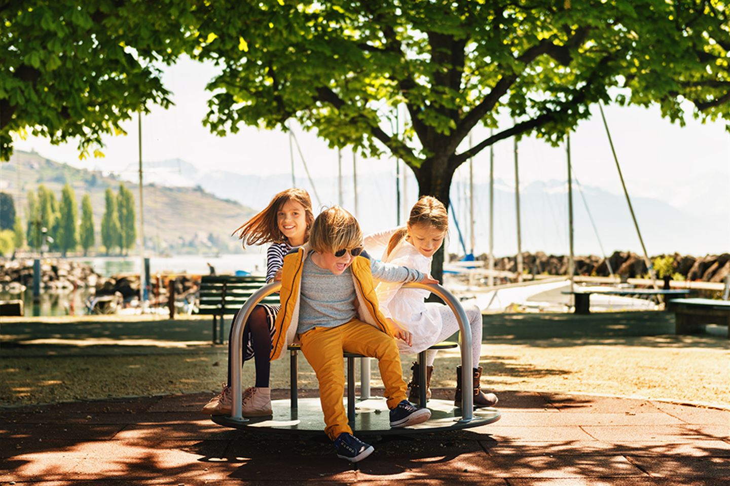 Illustrasjonfoto av tre ungar som leikar ute i sola
