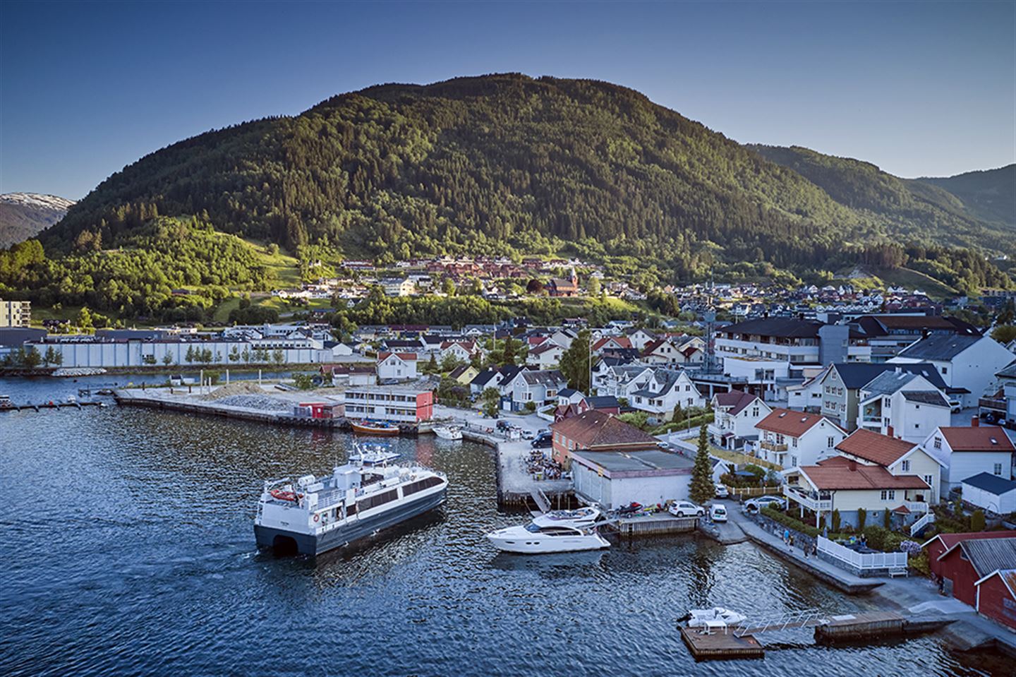 Oversiktsbilde over hurtigbåtkaien i Sogndal. Hurtigbåten er i ferd med å leggja til kai.