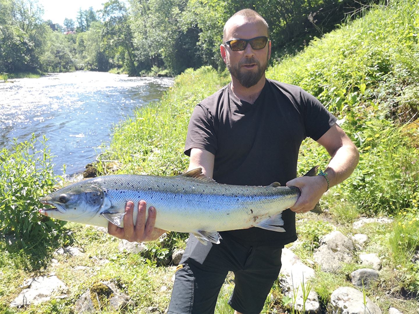 foto av mann som held ein fisk