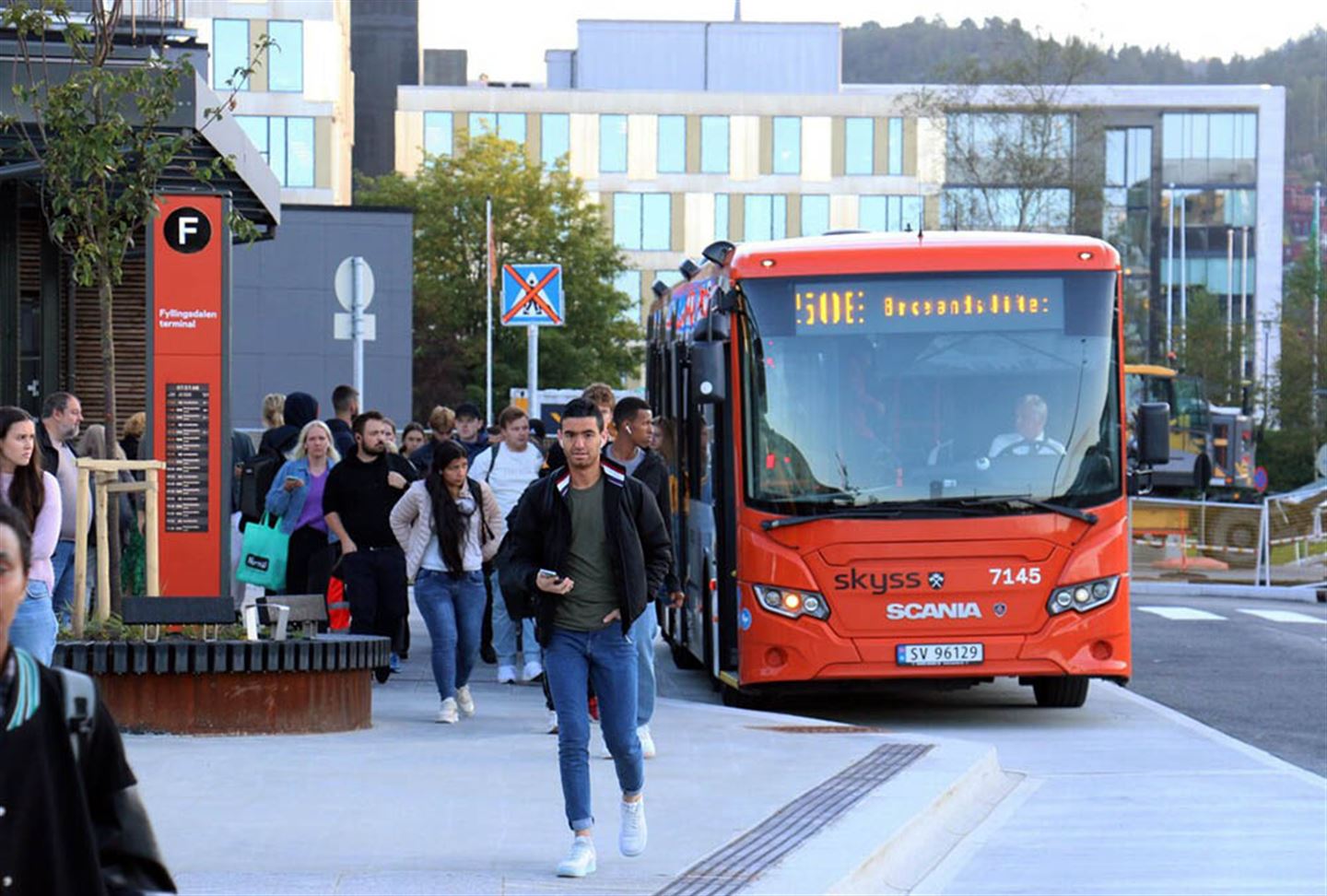 Buss på haldeplass og mange reisande.