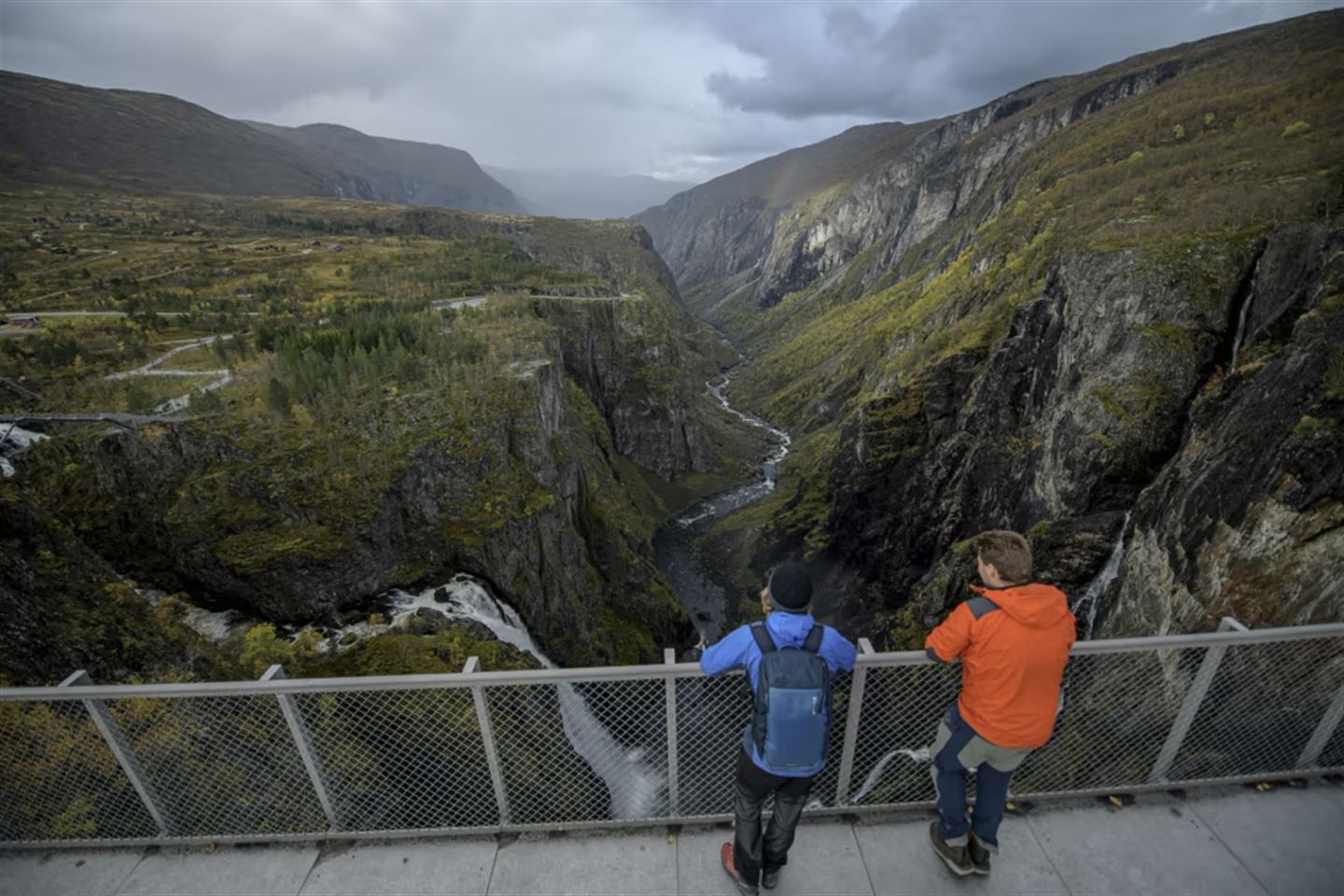 To personar som står på utkikkspunktet over Vøringsfossen.