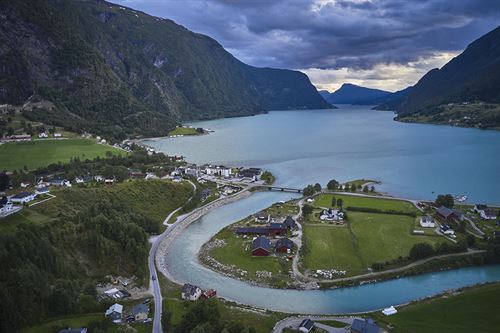 Oversiktsbilde over bygd med fjord og fjell.