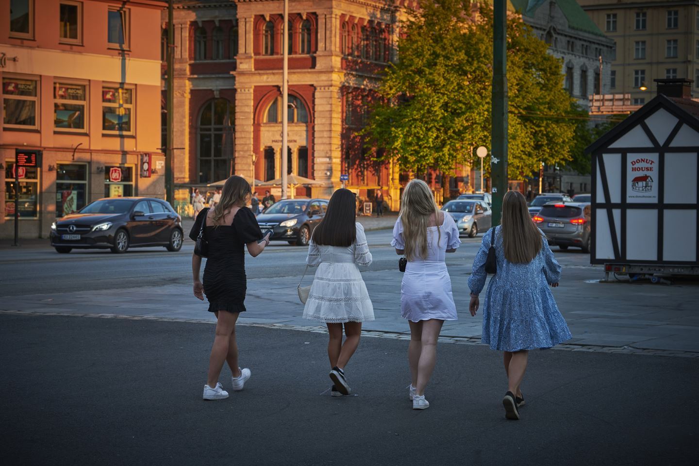 Foto av fire jenter som går tur i Bergen sentrum. Dei er avbilda med ryggen til.