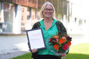 Renate Lunde med blomsterbukett og diplom med teksten Vinnar av bedriftsutviklingsprisen i landbruket i Vestlandet 2024.