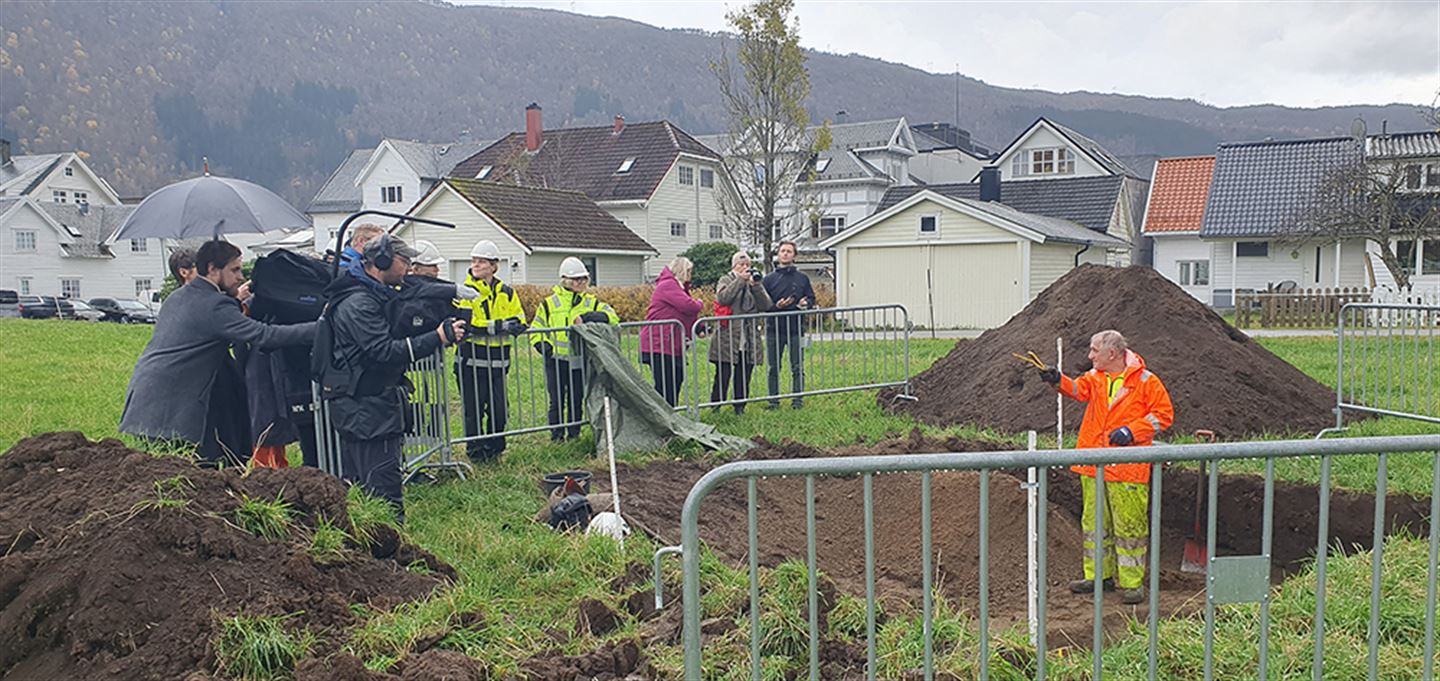 Mann i utgravingssjakt forklarer ting for publikum.