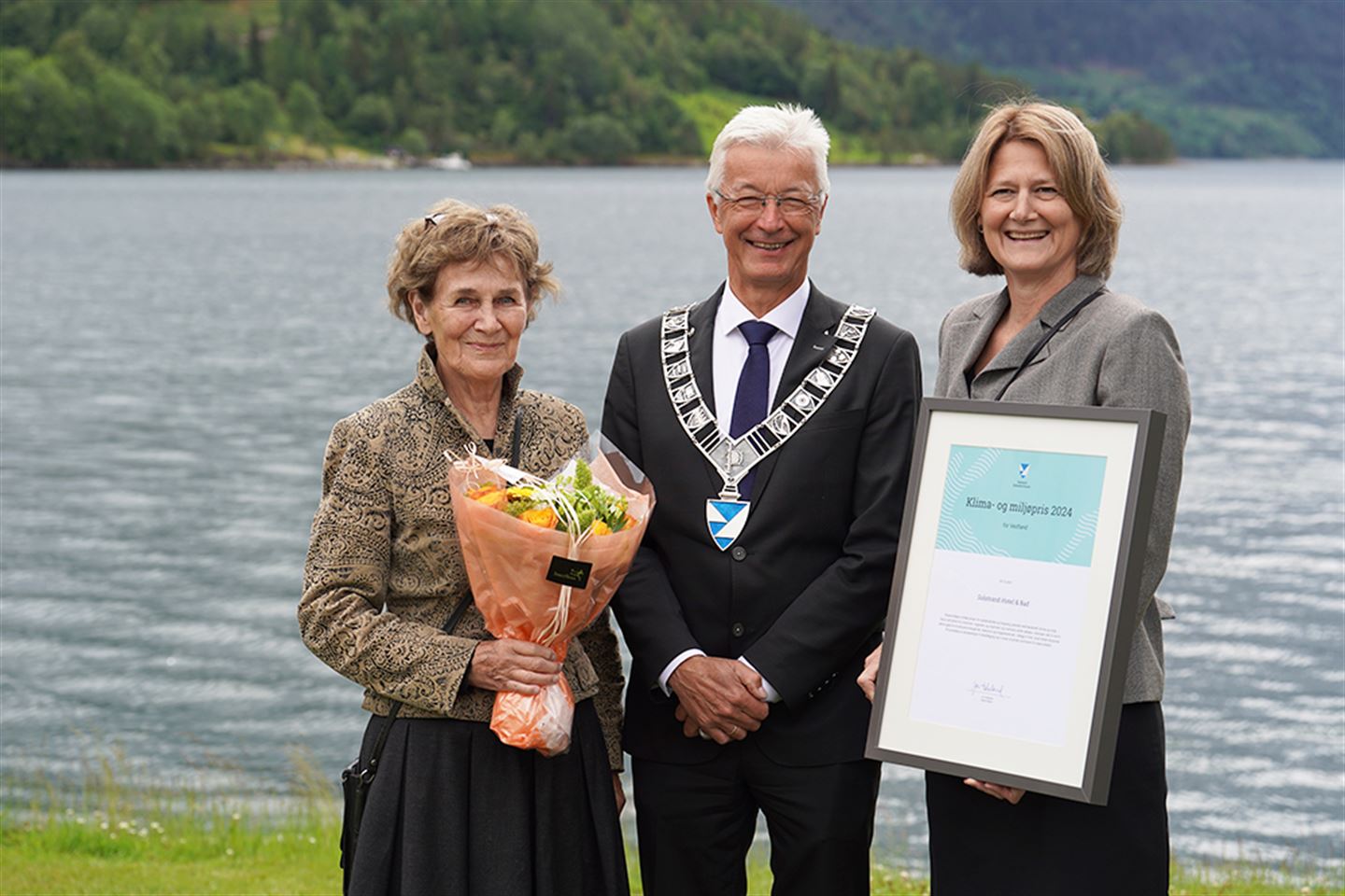 Fylkesordførar Jon Askeland saman med Børrea og Pernille Schau-Larsen som held høvesvis blomsterbukett og diplom for klima- og miljøprisen 2024.