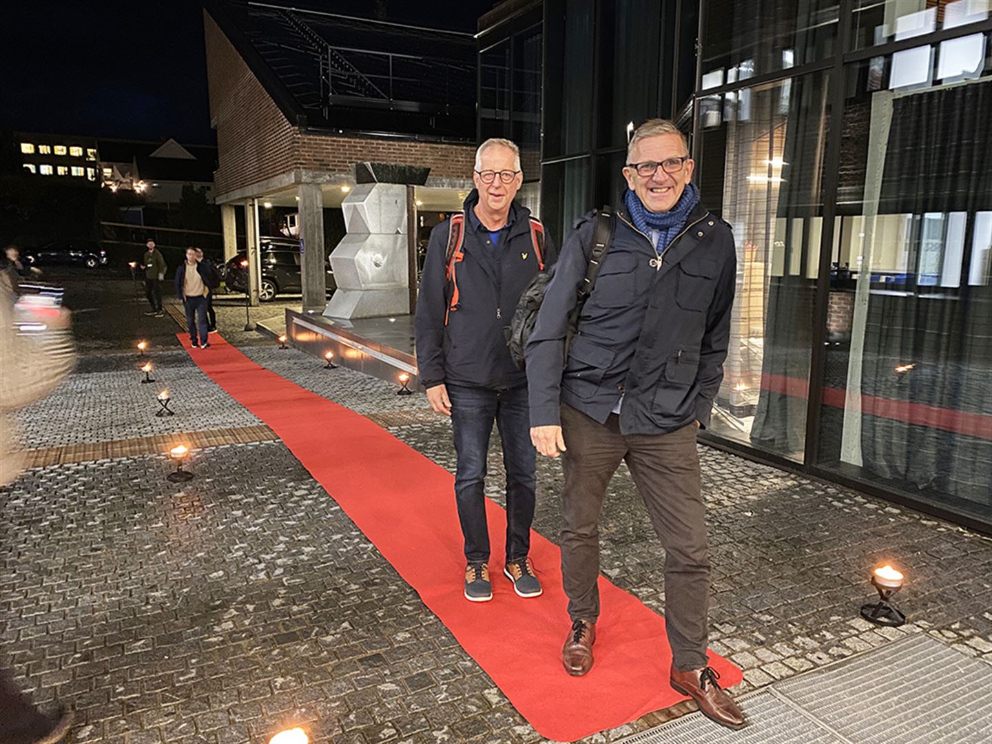 To menn på raud løpar på veg inn på fylkeshuset på Leikanger.