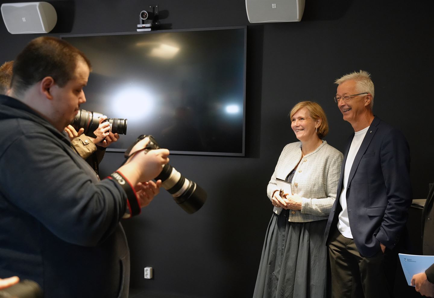 foto av pressefotografar og to personar som vert avbilda