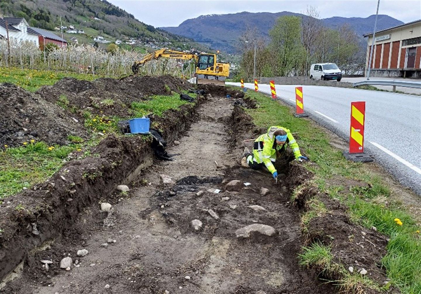 Arkeolog i arbeid i oppgraven sjakt ved riksveg 13 i Leikanger.