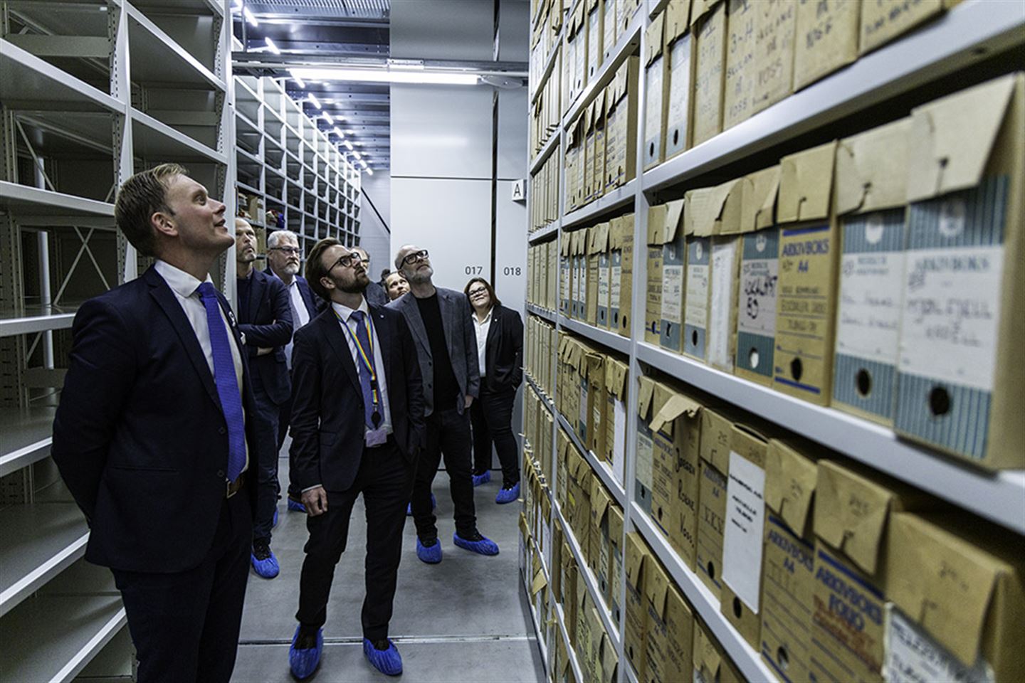 Menneske på synfaring i arkivmagasin.