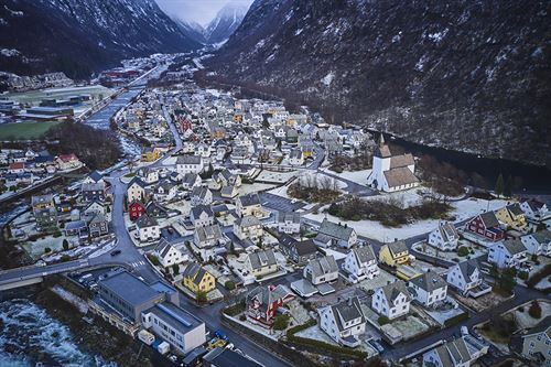 Dronefoto av bustadområde og kyrkja i Høyanger.