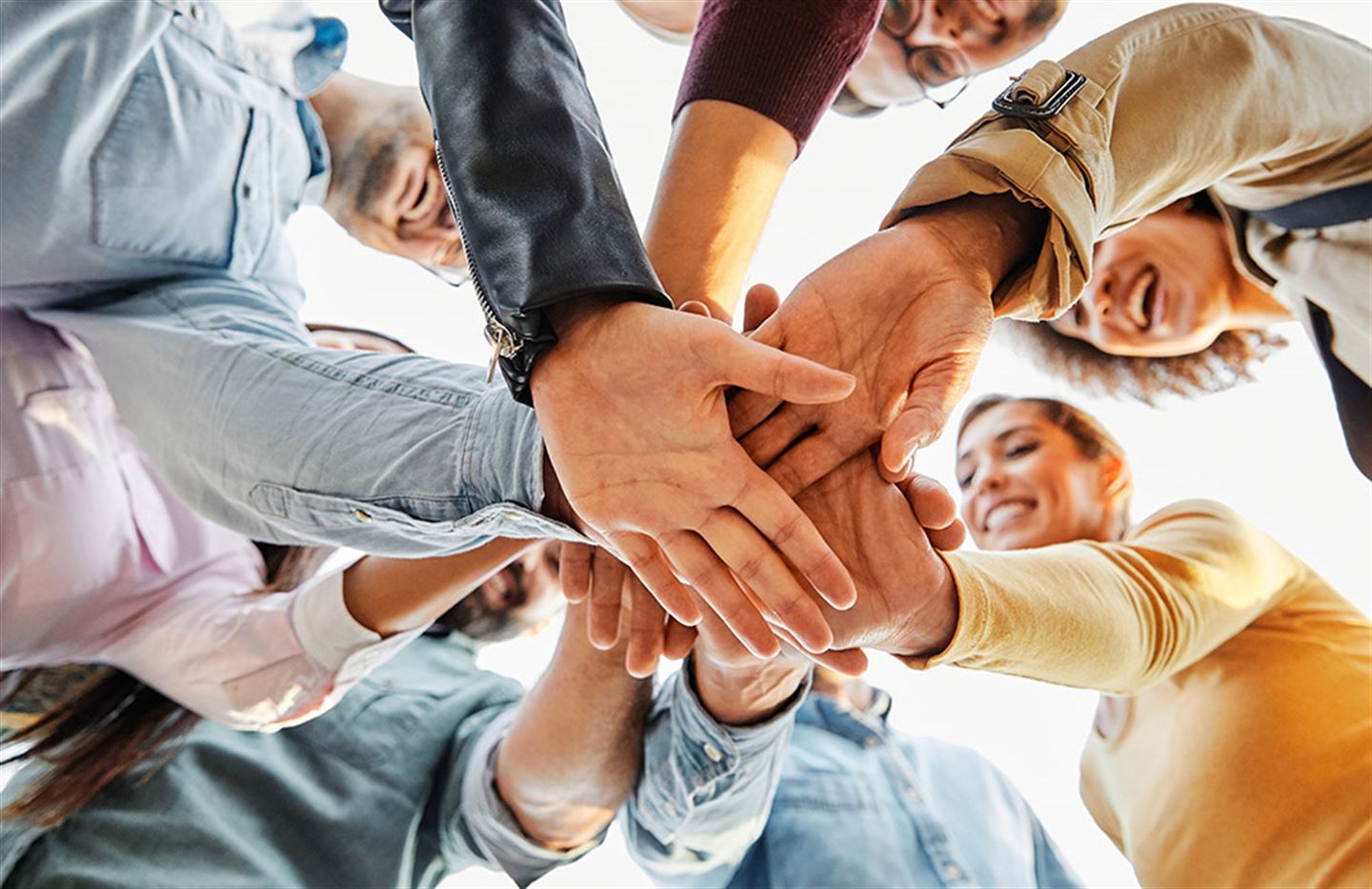 Hendene til unge mennesker sett nedanfrå.