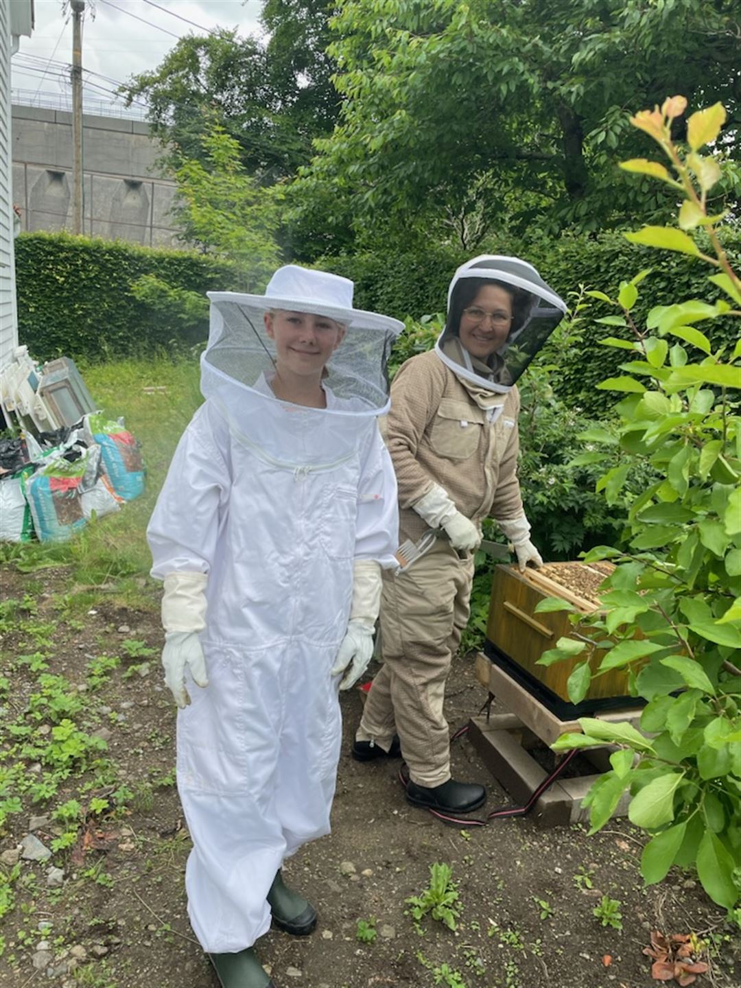 foto av to personar i birøktardrakt