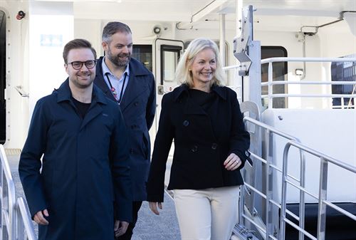 Klima- og miljøminister Sigrun Aasland, fylkesvaraordførar Stian Davies og askøyordførar Yngve Fosse på veg ut av ein båt.