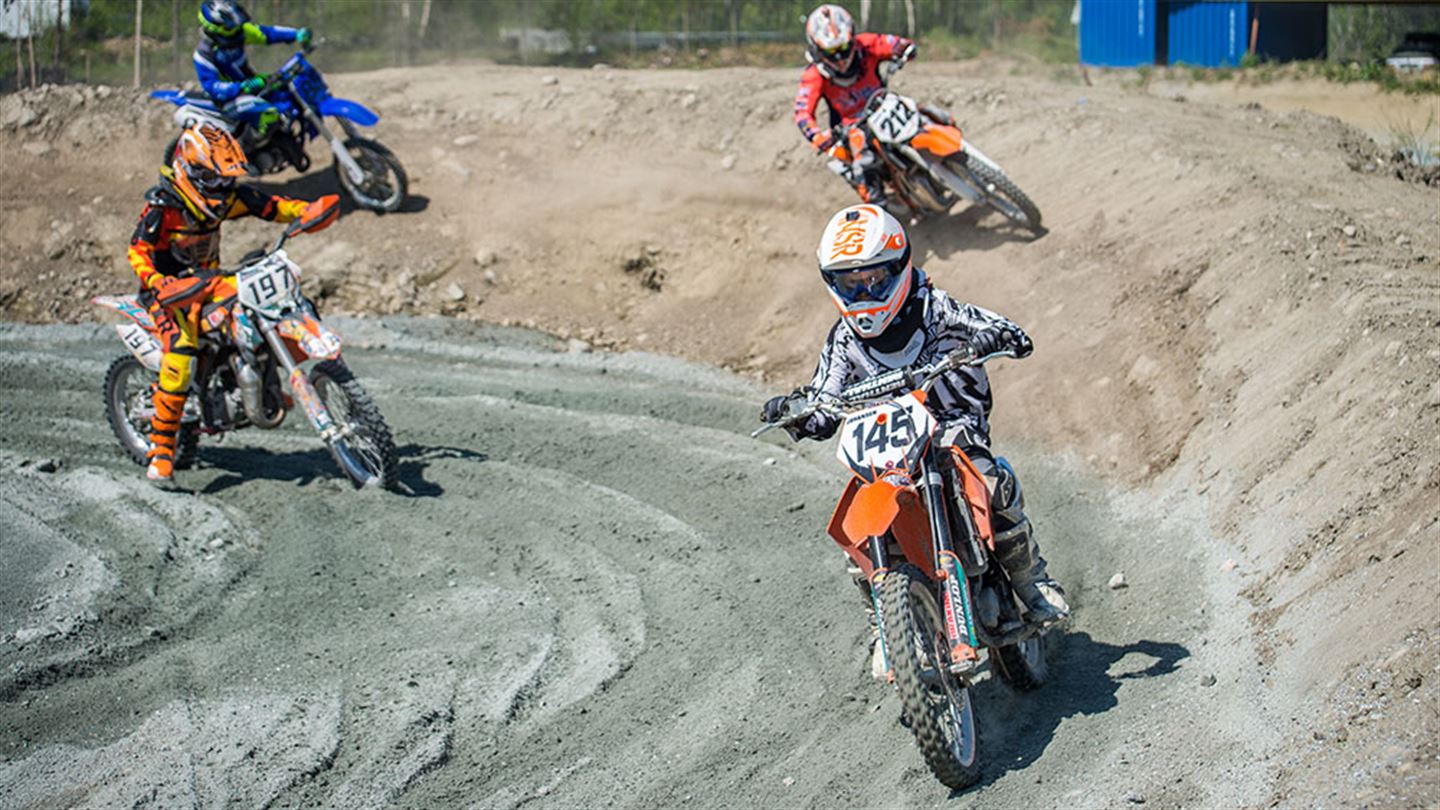 Ungar/ungdomar som køyrer motorcross på bane.