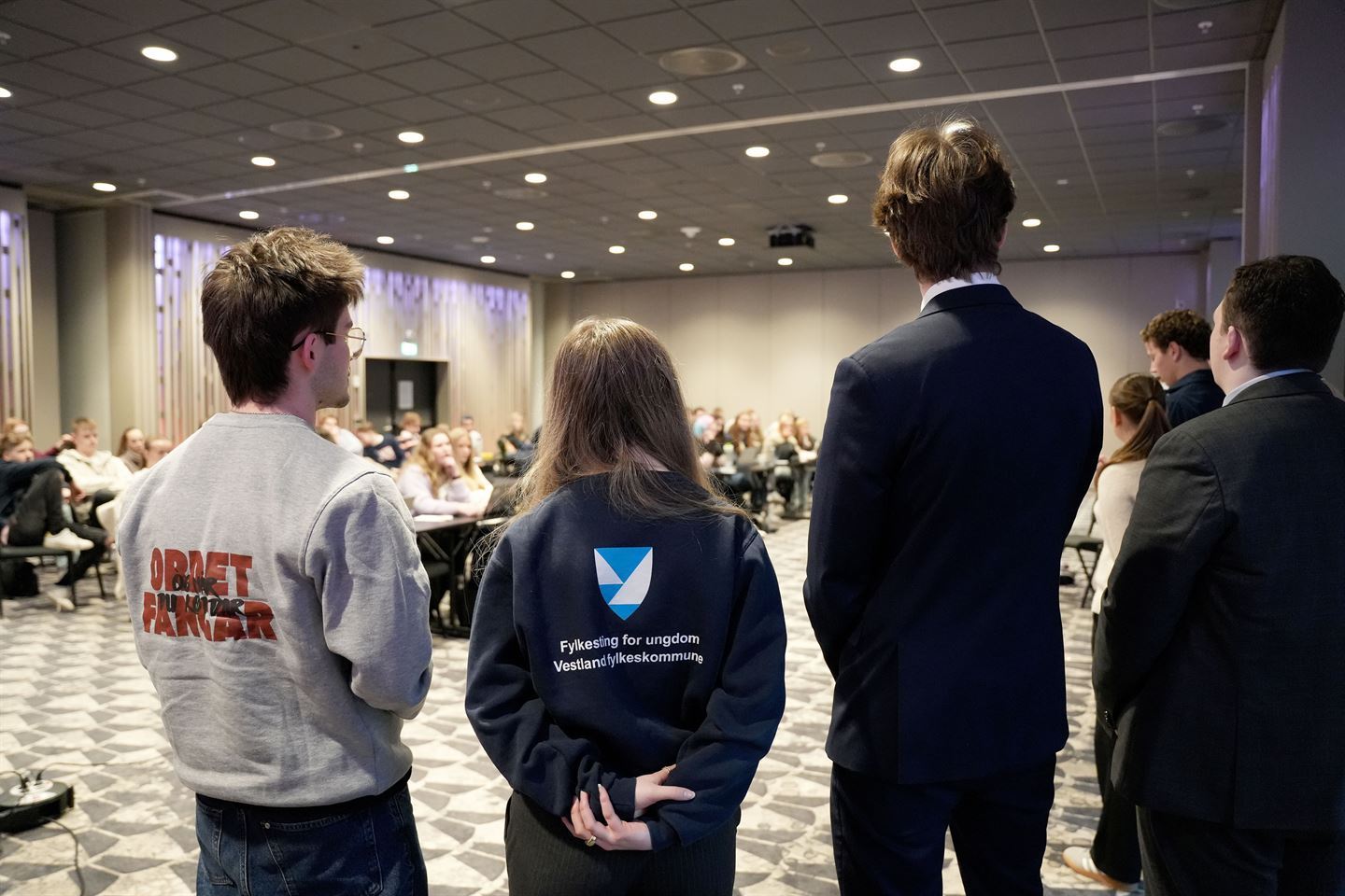 Foto av personar med ryggen til