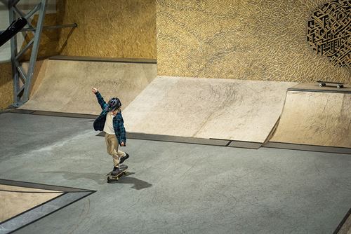 gut med skateboard i skatehall