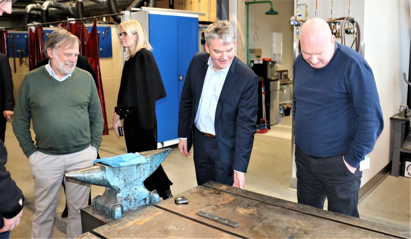 Omvising på verkstad med ambolt og arbeidsbenk og personar