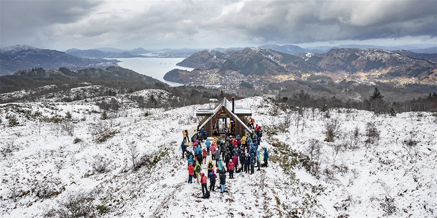 Dagsturhytta Brakabu på Osterøy i vinterlandskap og med ein del folk utanfor.