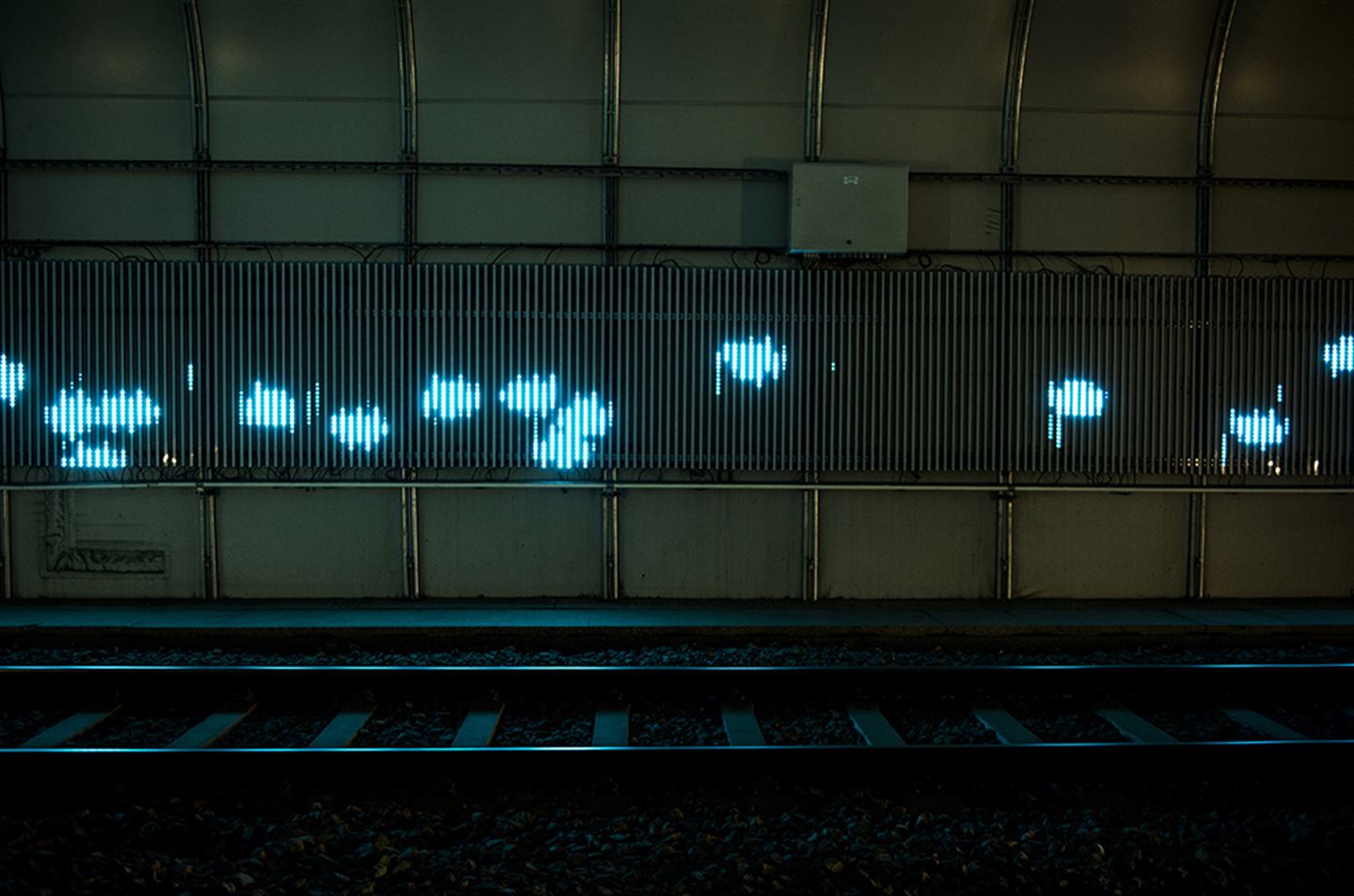 foto av kunstverket Kjankaren langs bybanetraseen. Det er turkis lys på ein tunnelvegg.