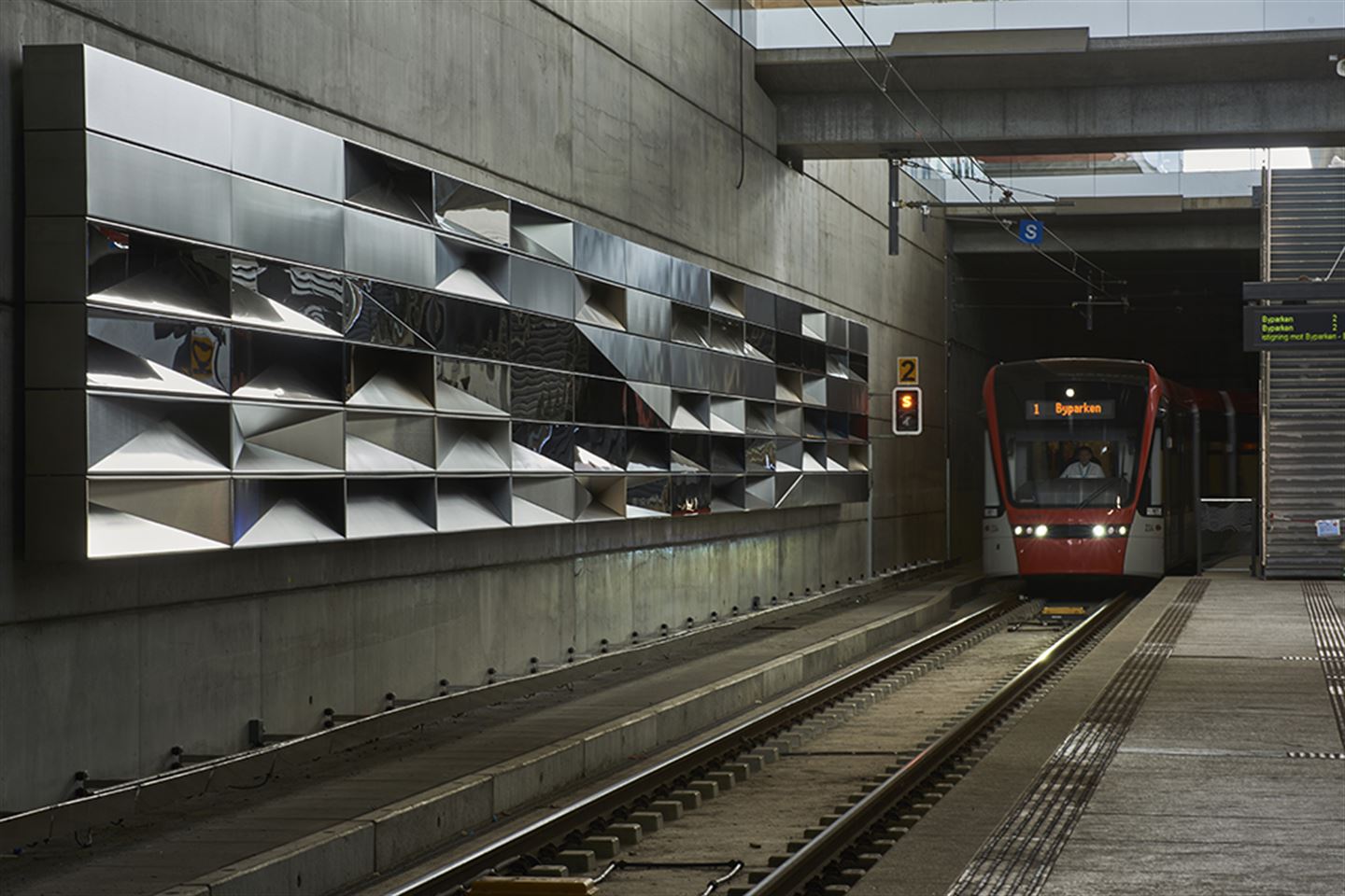 foto av kunstverket Modulære refleksjoner på bybanestoppet på Flesland. Det er vegg av speglar i ulike vinklar.