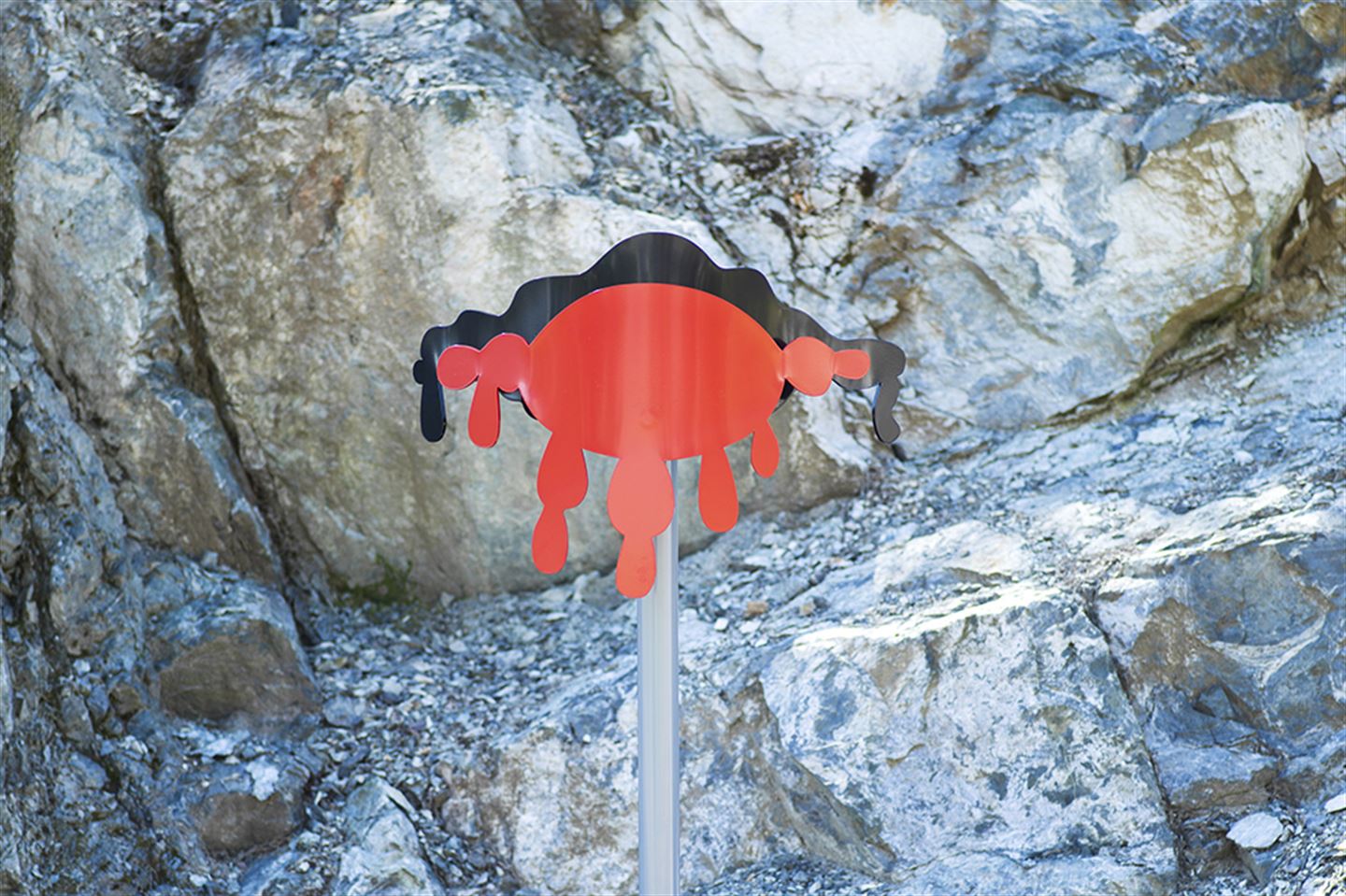 foto av kunstverket Olje-Norge langs bybanetraseen. Det er ein raud figur festa øvst på ein stolpe.