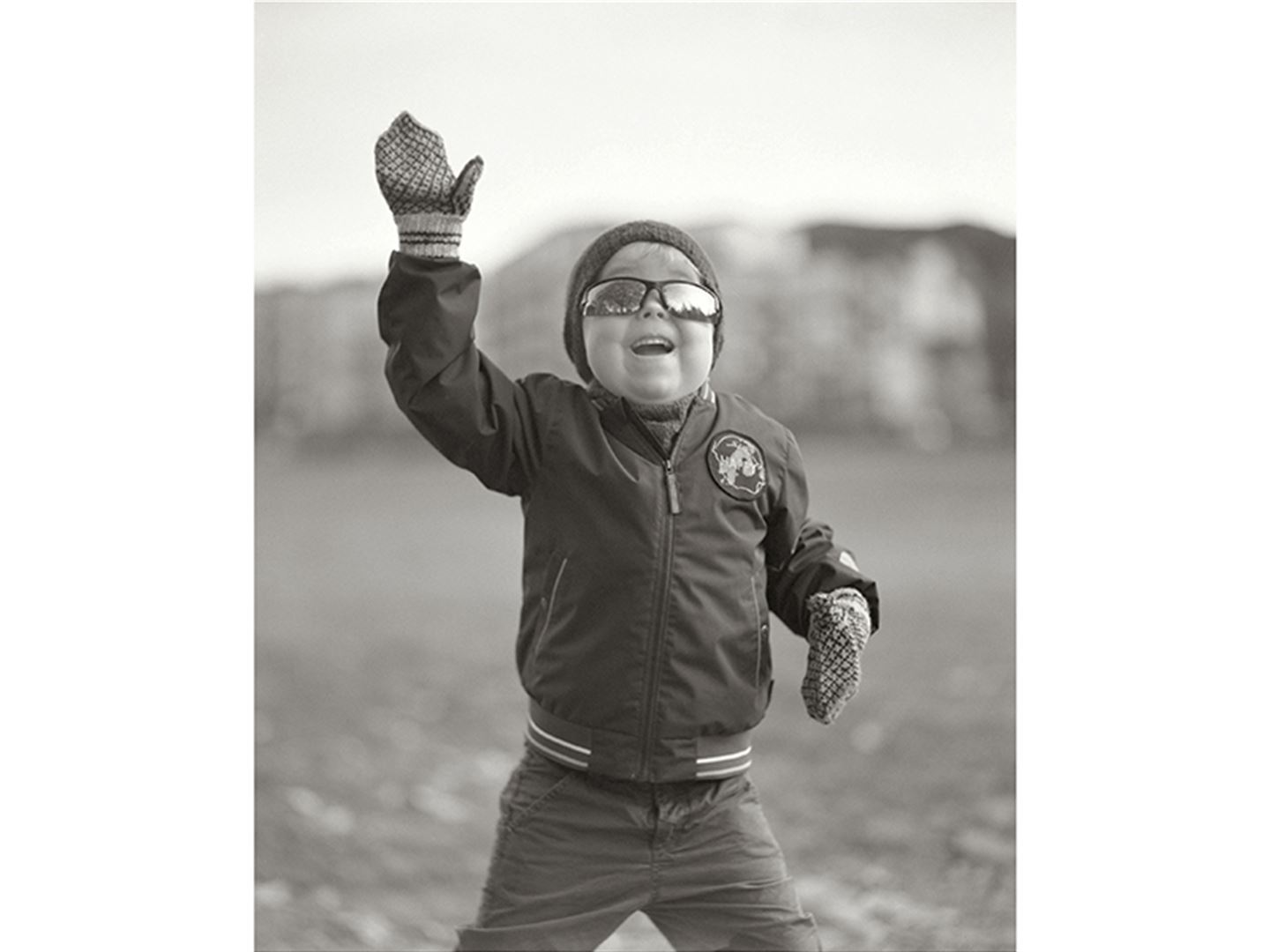 svart-kvitt-foto av liten gut med solbriller
