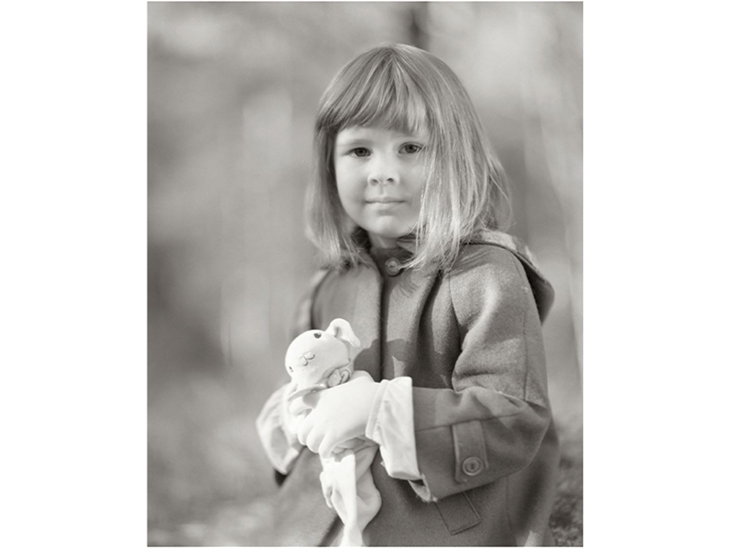 svart-kvitt-foto av jente som held bamse