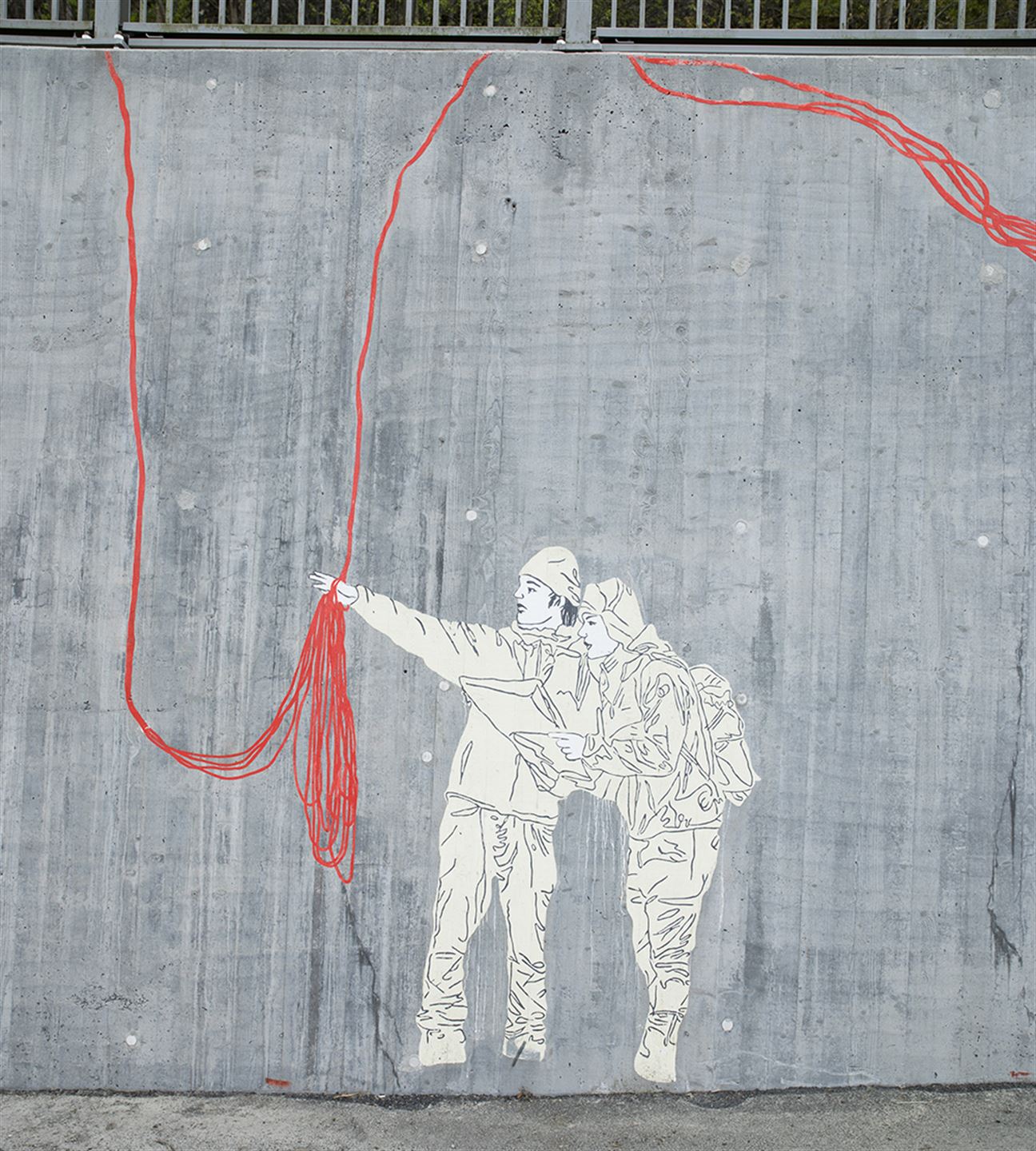 Foto av kunstverket 1: 1 000 483 langs bybanetraseen. Kunstverket er målt på betong og syner to menneske som snakkar saman og raude strekar.
