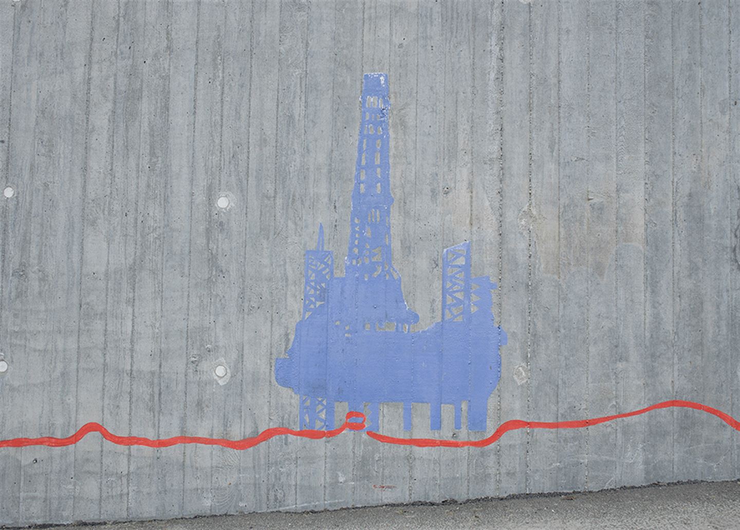 Foto av kunstverket 1: 1 000 483 langs bybanetraseen. Kunstverket er målt på betong og syner ei oljeplattform målt i blått og raude strekar under.