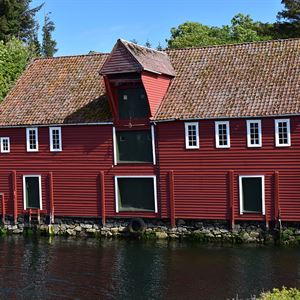 Gamalt, raudt bygg ved sjøen.