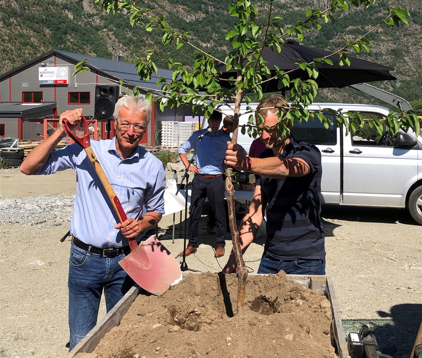 Fylkesordførar Jon Askeland markerer byggestart for pakkeriet på Håbakken ved å plante eit morelletre. Foto: Endre Høgalmen/Vestland fylkeskommune.