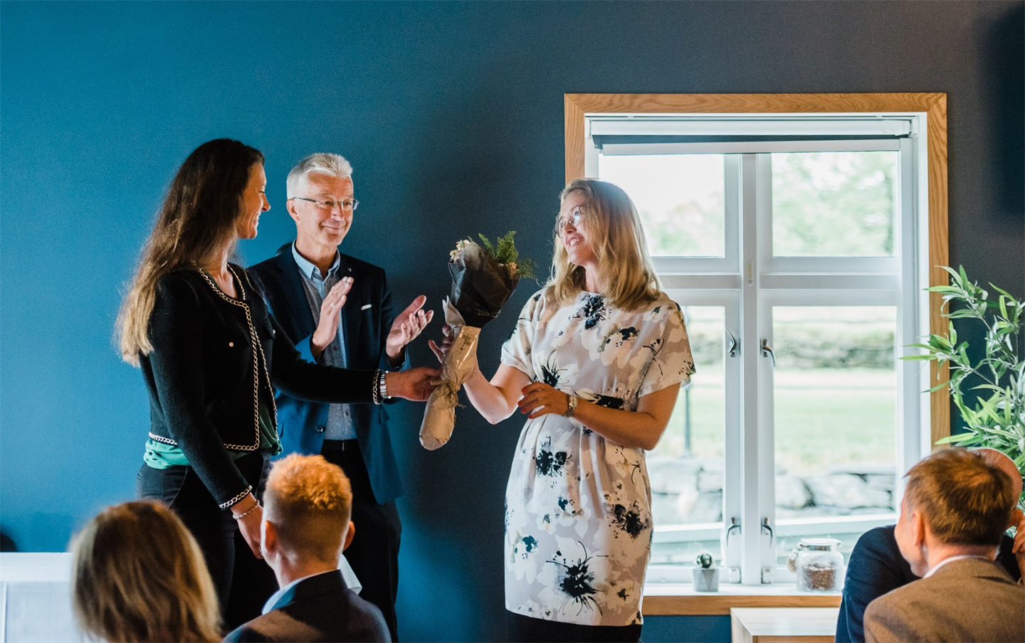 renate nedregård får blomster av fylkesordførar og fylkesvaraordførar.
