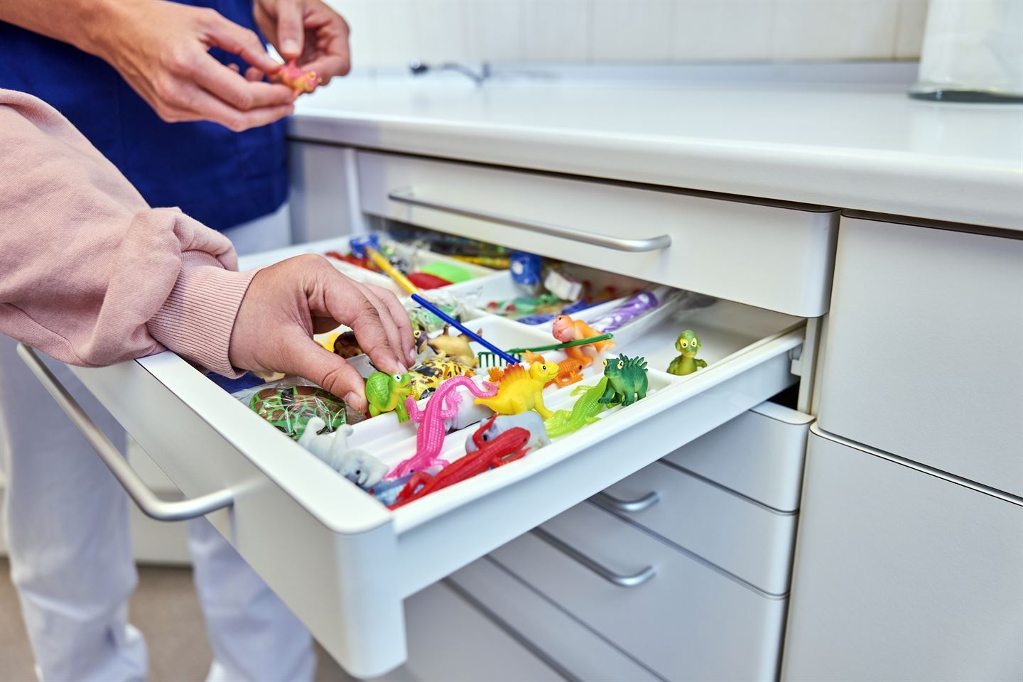 Barnehånd velger plastleke hos tannlegen.